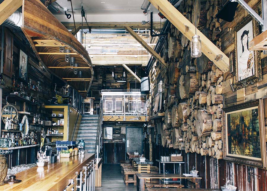 Looking into the dining room at the Brown Owl, an old wooden canoe hangs from the ceiling, timber lines the walls.